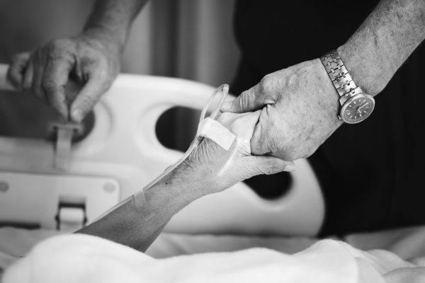 Husband holding hands of his wife in a hospital Husband holding hand with his wife in a hospital